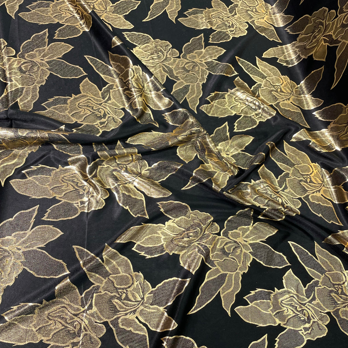 Black stretch polyester fabric with metallic gold foil rose motifs