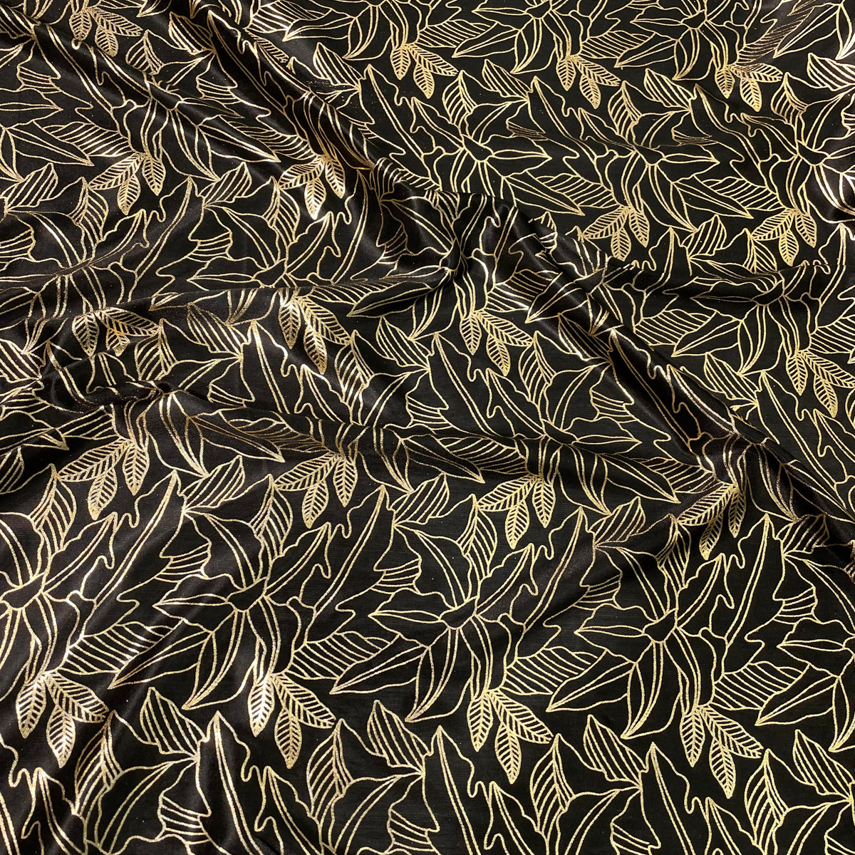 Black stretch polyester fabric with metallic gold foil floral line-art design