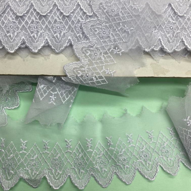 White 4-inch polyester floral lace trim with decorative openwork detailing