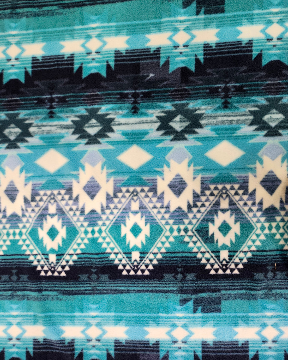 Soft Aztec polyester fleece fabric with a plush brushed texture for blankets, apparel, and crafts