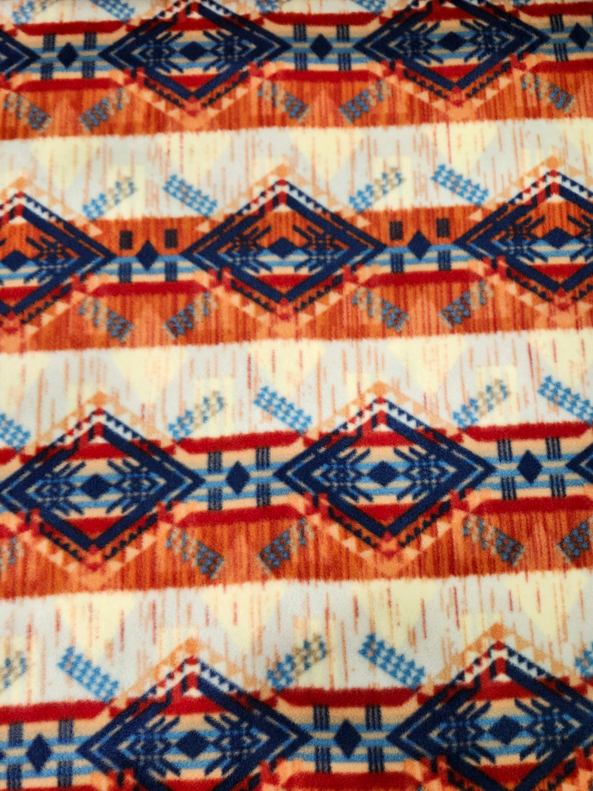 Soft Aztec polyester fleece fabric with a plush brushed texture for blankets, apparel, and crafts