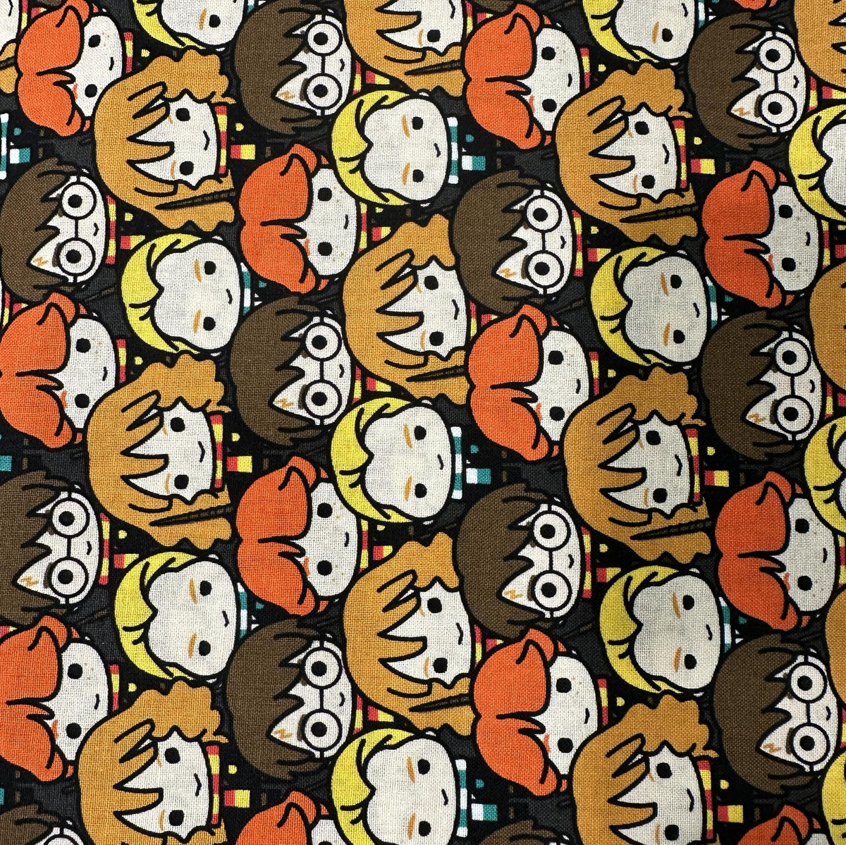 Brown and orange Harry Potter cotton fabric with repeating stylized character faces on a dark background