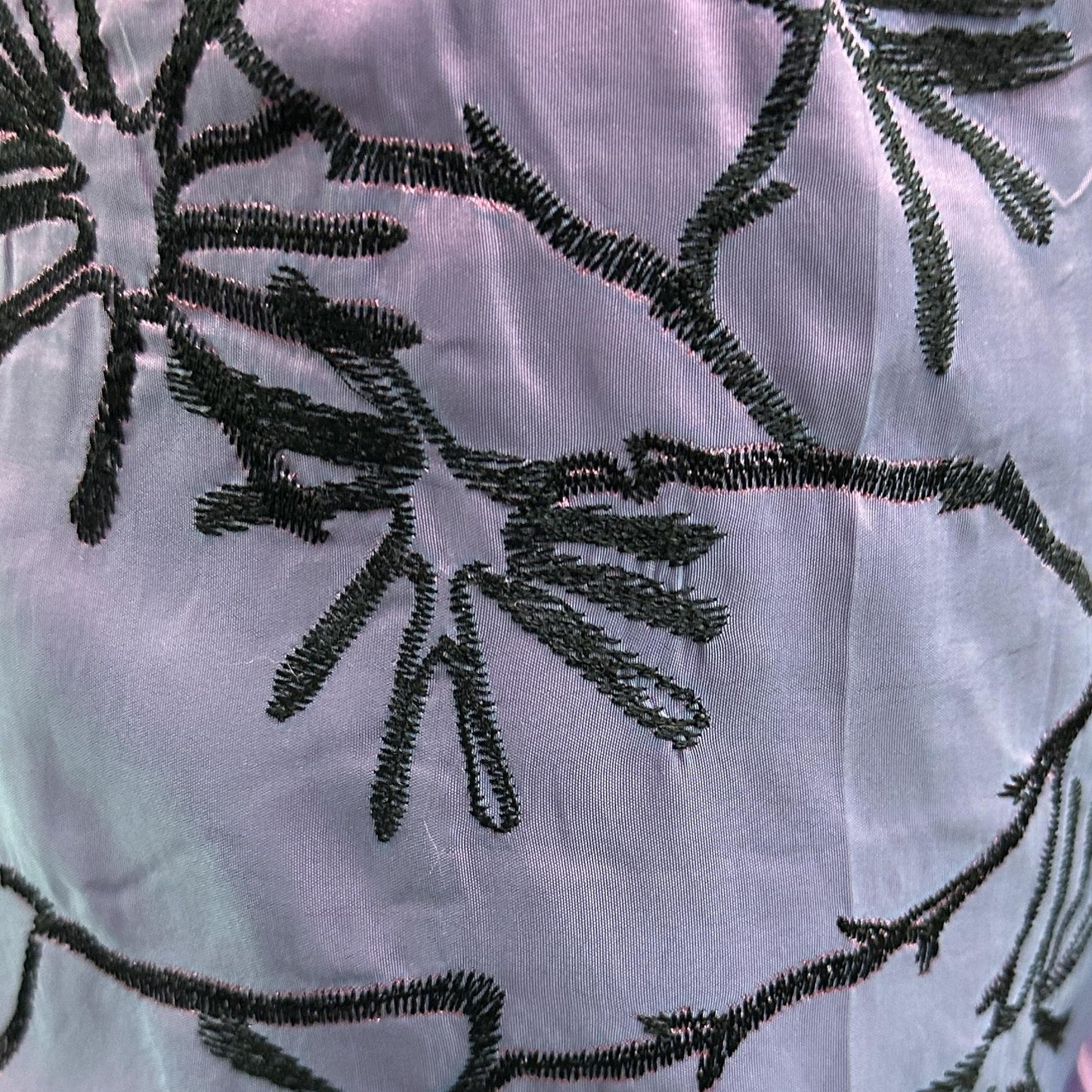 Beige and black embroidered drapery fabric with a decorative textured pattern