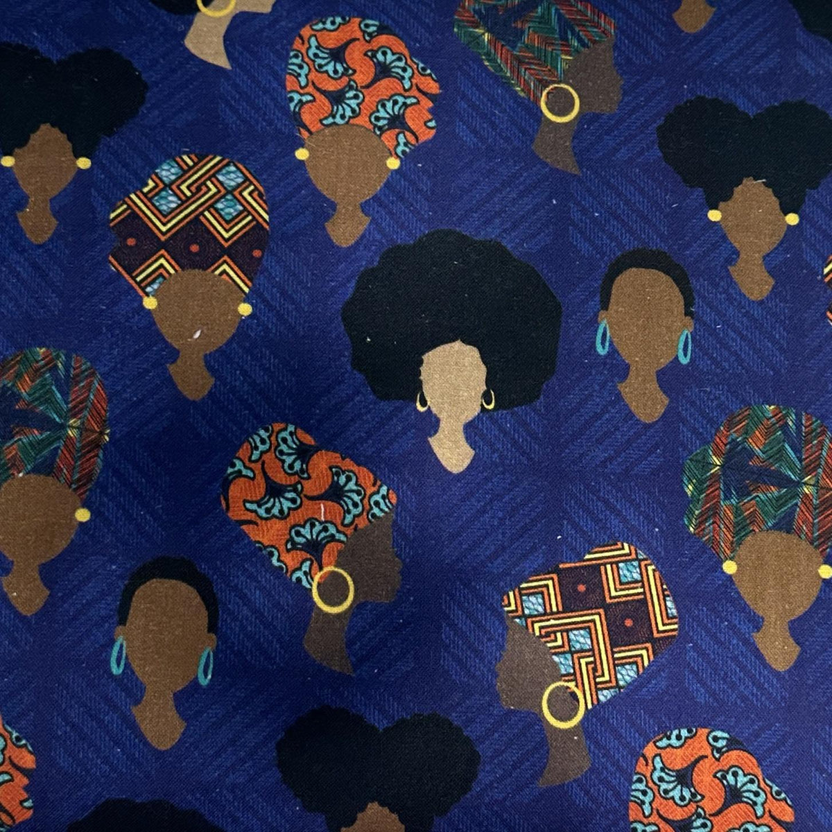 Blue African-inspired cotton fabric with a repeating illustrated woman portrait print