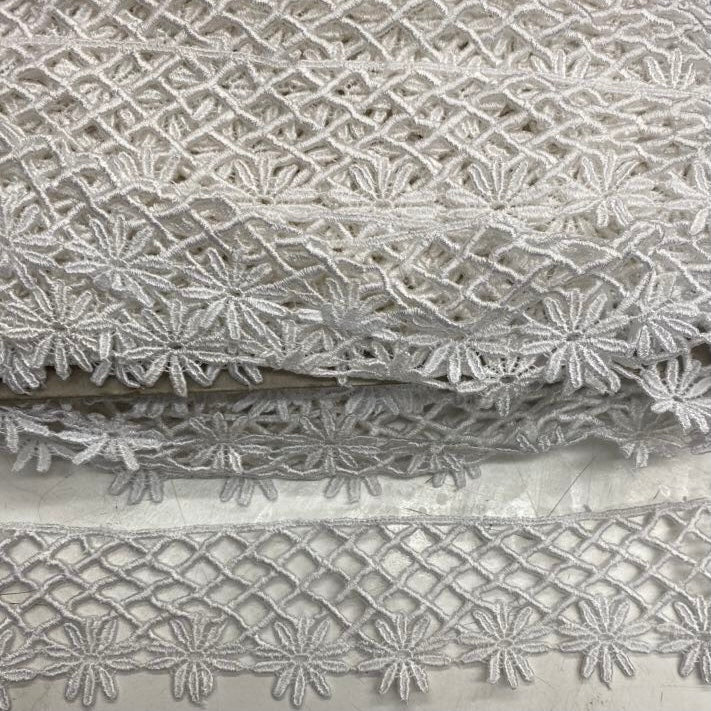 White lace trim with floral embroidery, geometric openwork and decorative scalloped edging