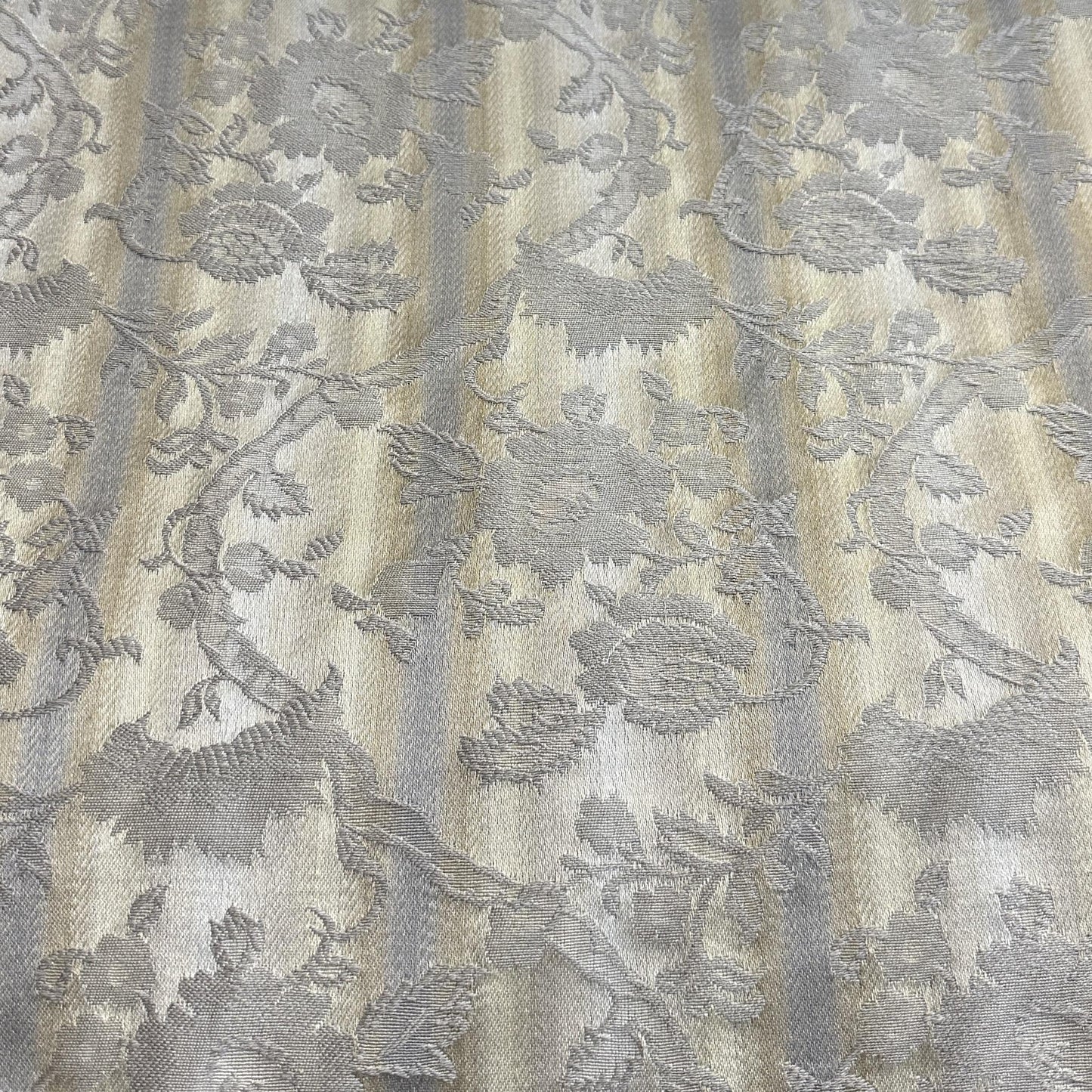 Beige and grey polyester fabric with a neutral floral pattern for upholstery and home décor