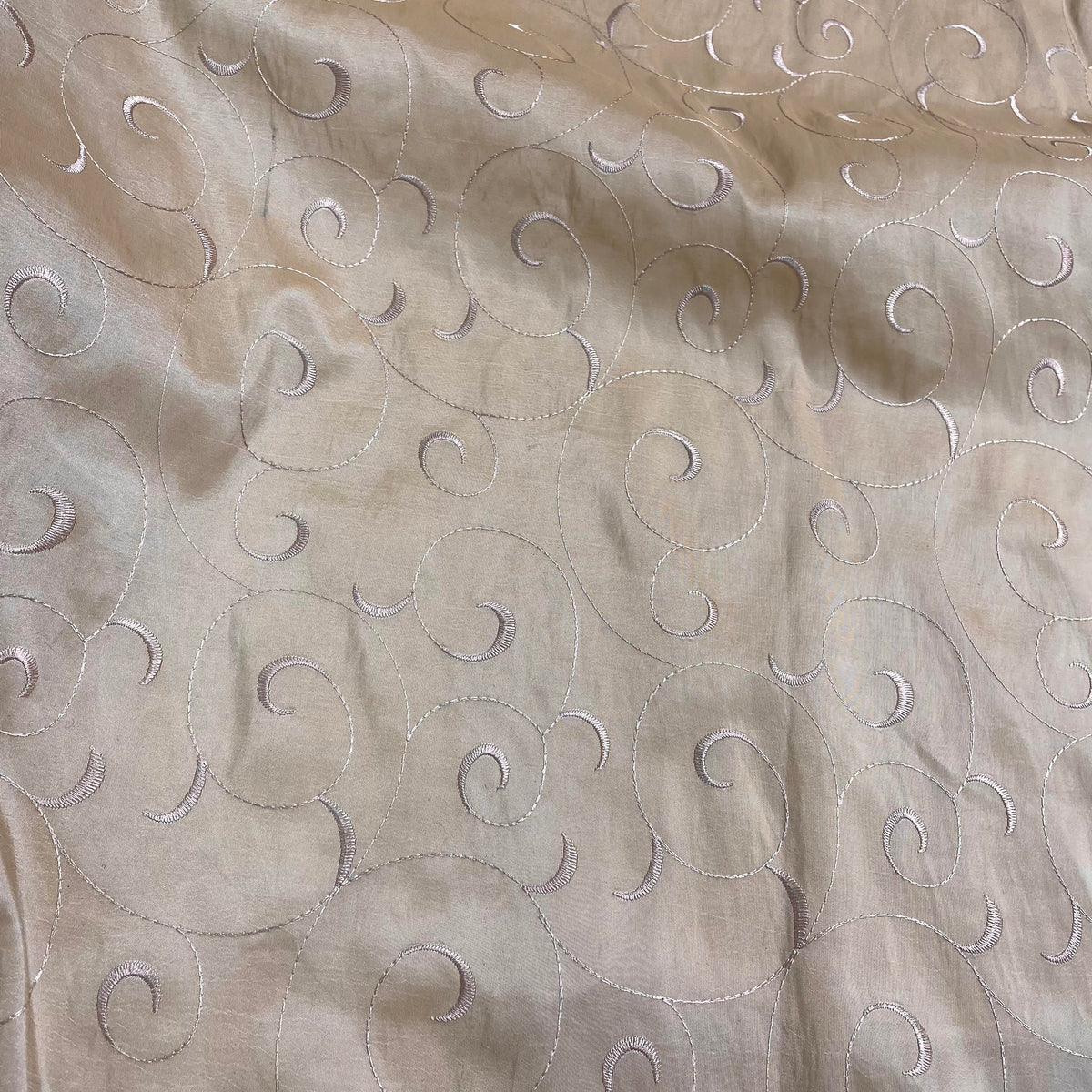 Champagne beige polyester taffeta fabric with a decorative vine-inspired pattern and subtle sheen