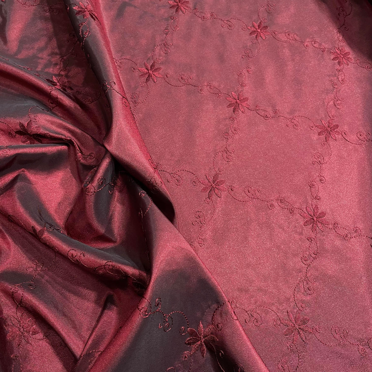 Red polyester taffeta fabric with a decorative floral pattern and subtle sheen