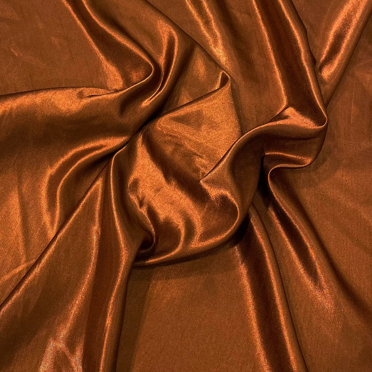 Rust gold polyester satin fabric with a smooth, lustrous surface and warm metallic-toned colour