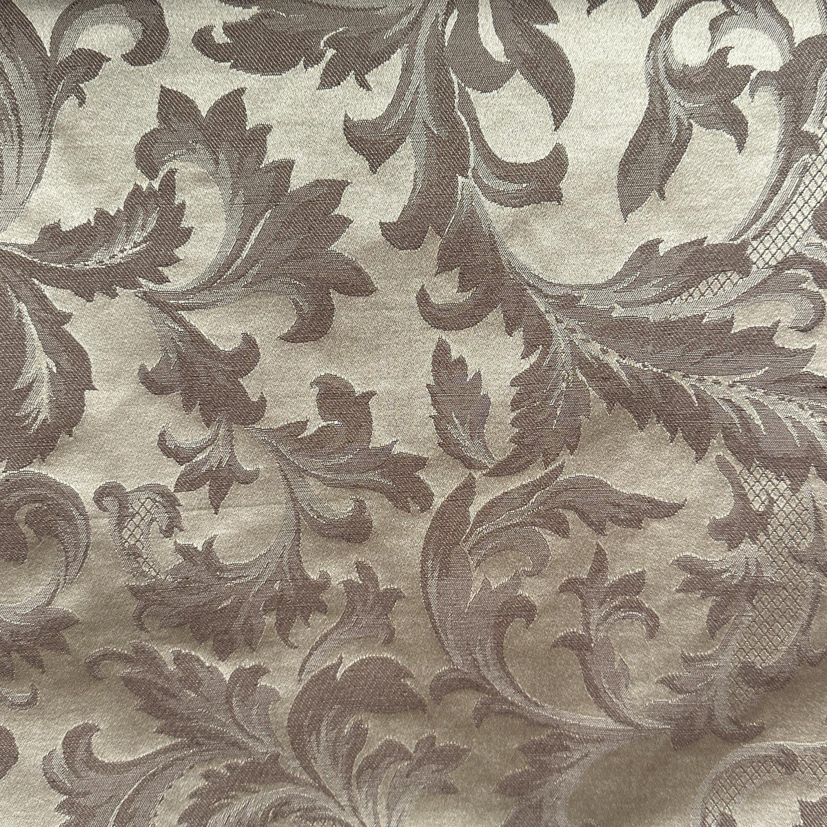 Beige and brown drapery fabric with a decorative leaf and floral pattern