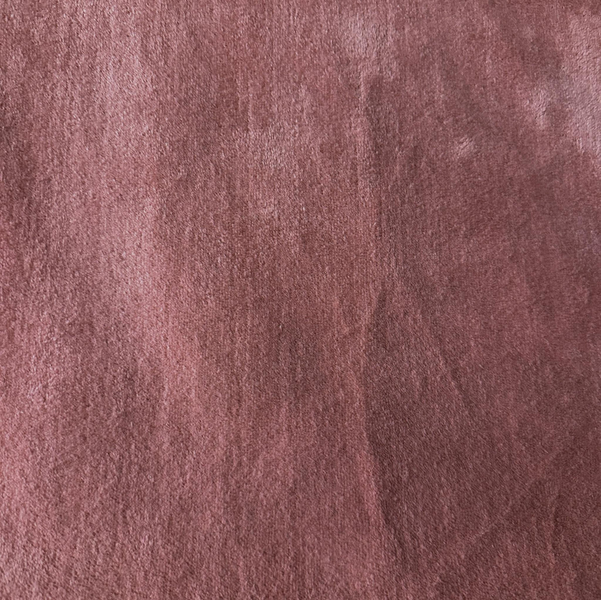 Solid pink velvet upholstery fabric with a smooth plush pile and subtle shading