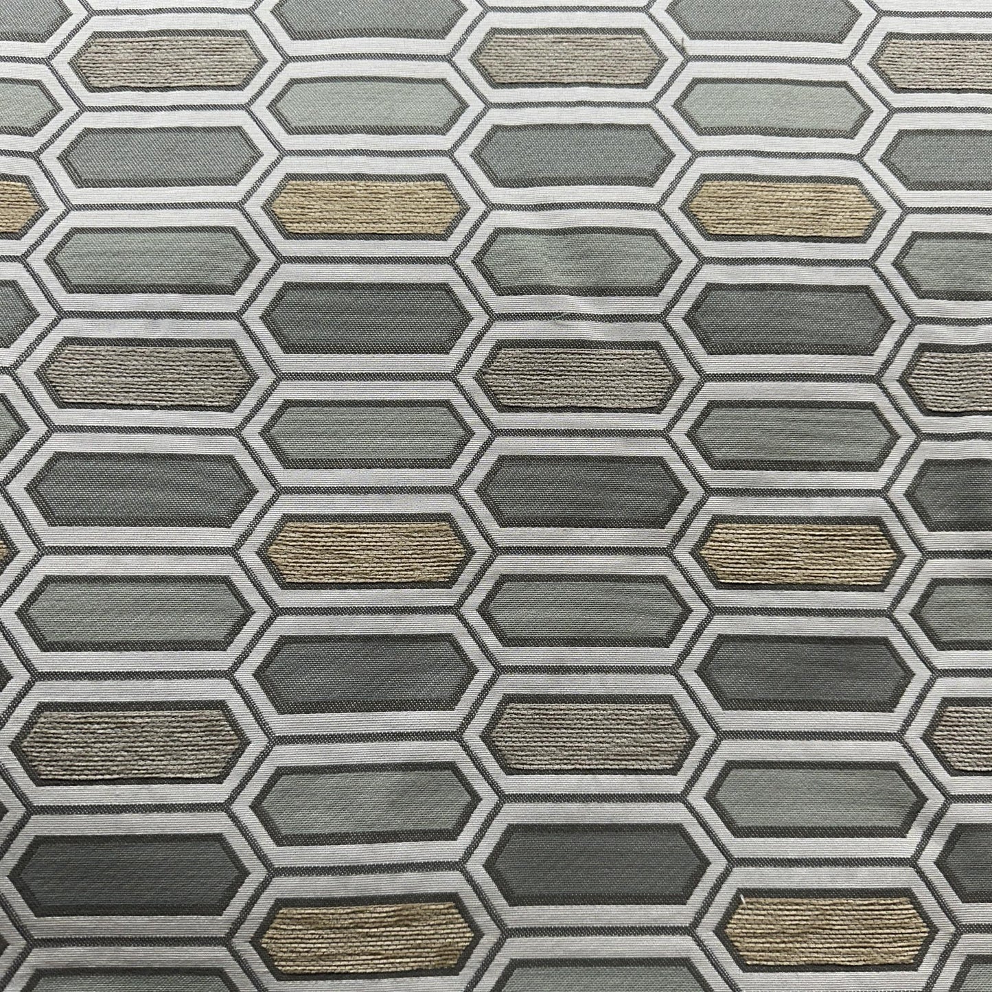 Grey and beige upholstery fabric with repeating elongated hexagon geometric shapes