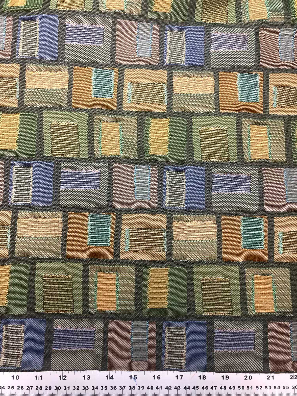Polyester upholstery fabric with multicolour geometric blocks in green, blue, beige, brown and aqua