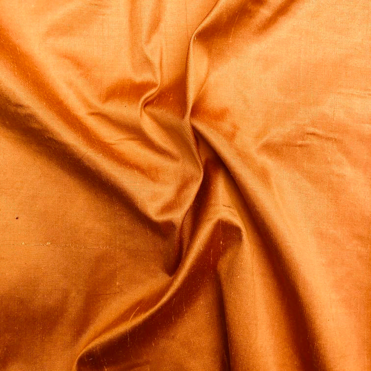 Dupioni silk fabric in mandarin orange with crisp textured finish