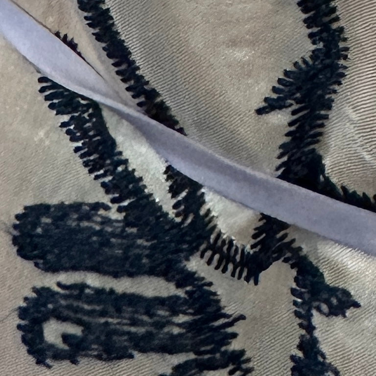 Beige, black and grey embroidered drapery fabric with a decorative textured pattern