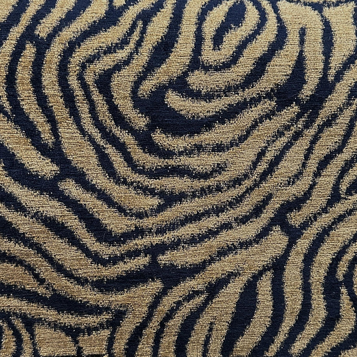 Gold tiger print upholstery fabric with flowing dark stripes and a textured animal pattern