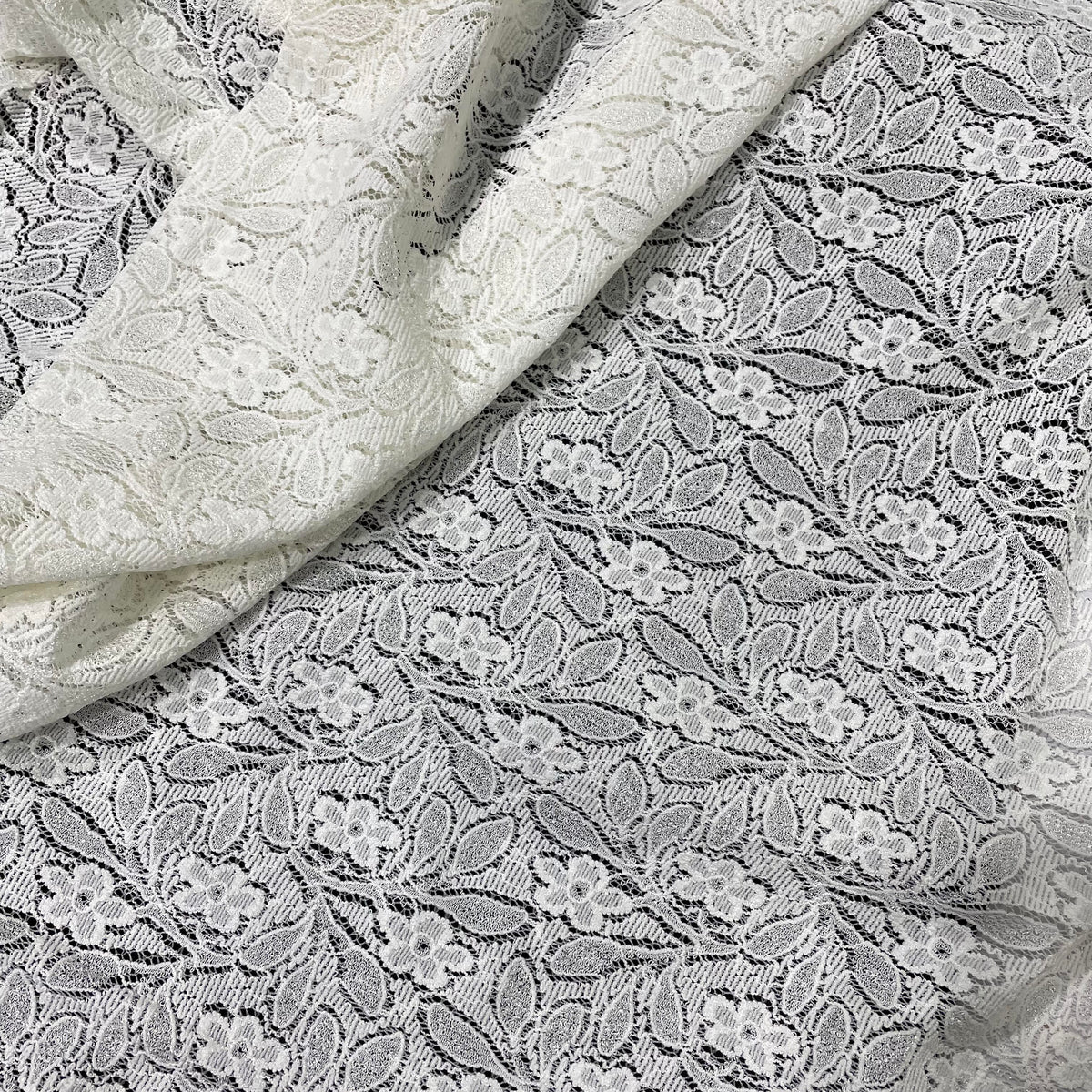 Ivory stretch lace fabric with a soft decorative openwork pattern and flexible construction