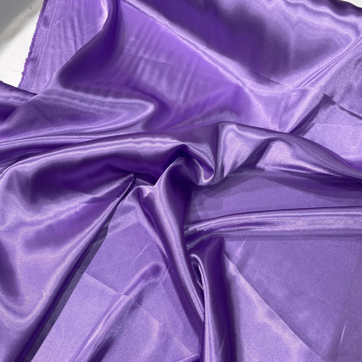 Lilac purple polyester satin fabric with a smooth lustrous surface and soft solid colour