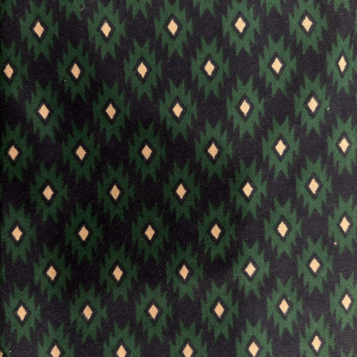 Green, black and beige flannel fabric with repeating geometric diamond and angular block pattern