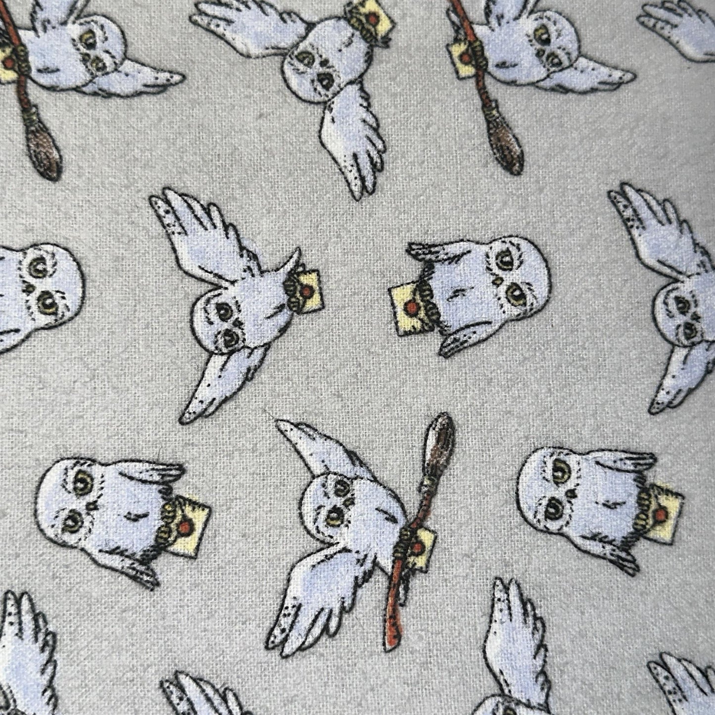 Grey Harry Potter flannel fabric with repeating Hedwig owl illustrations and magical-themed accents