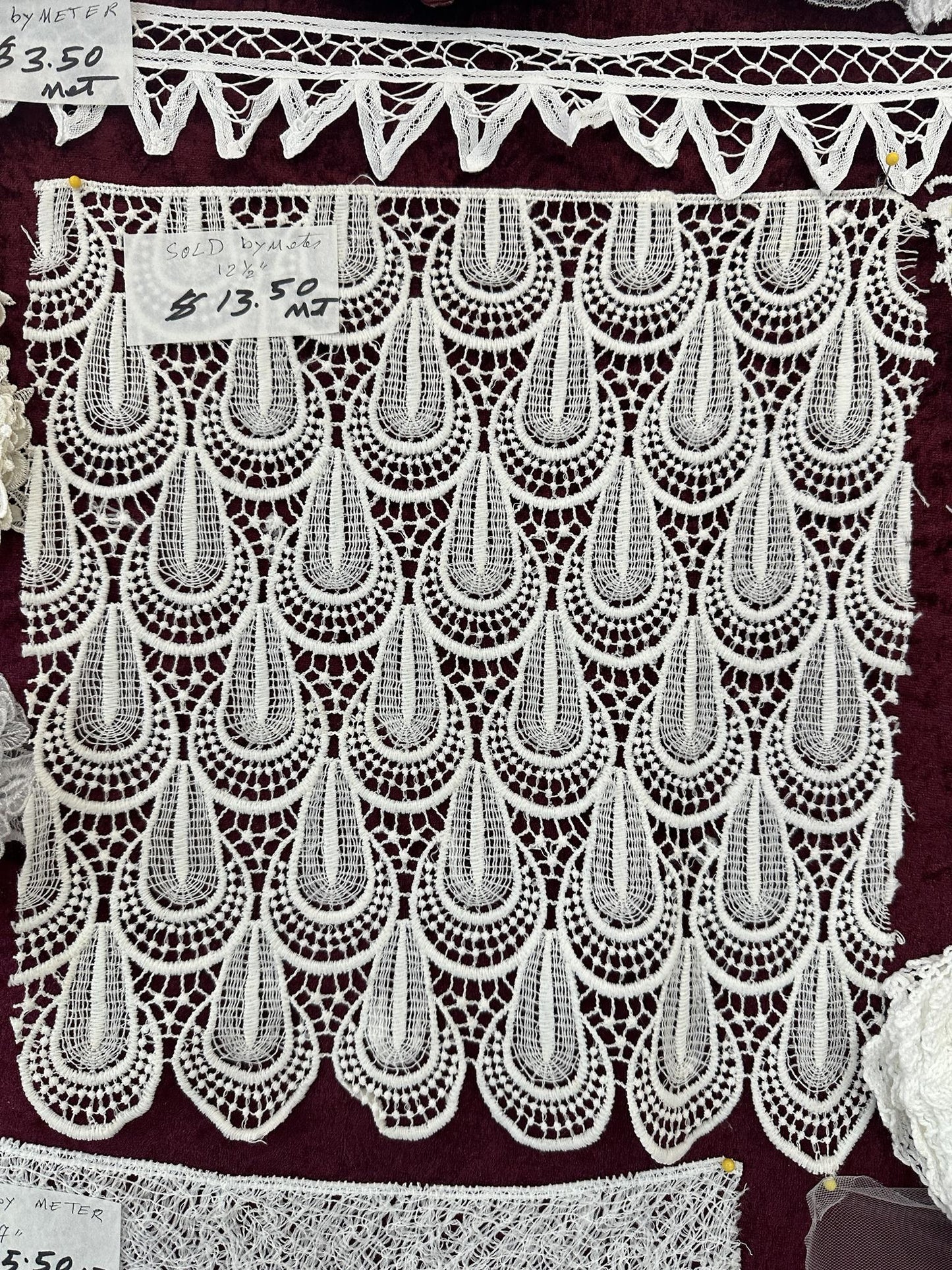 White 12.5-inch lace trim with ornate openwork teardrop motifs and scalloped edges