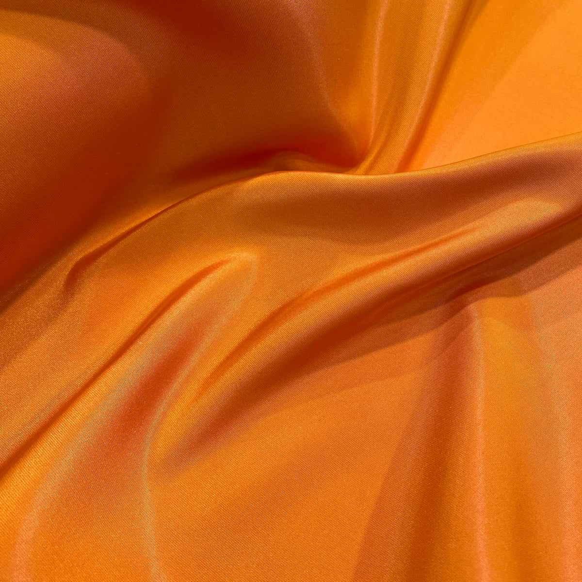 Sunset orange polyester taffeta fabric with a crisp surface and subtle sheen