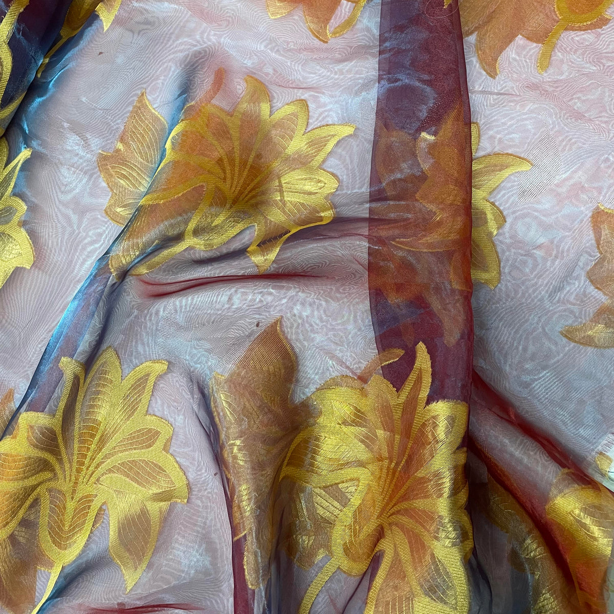 Iridescent polyester sheer fabric shifting between purple, red and yellow tones