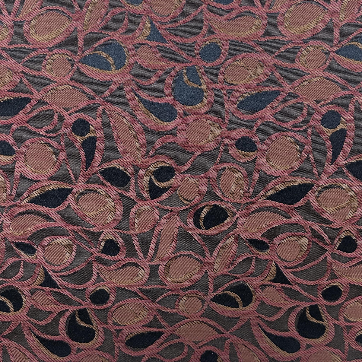 Red and brown floral upholstery fabric with an ornate repeating pattern