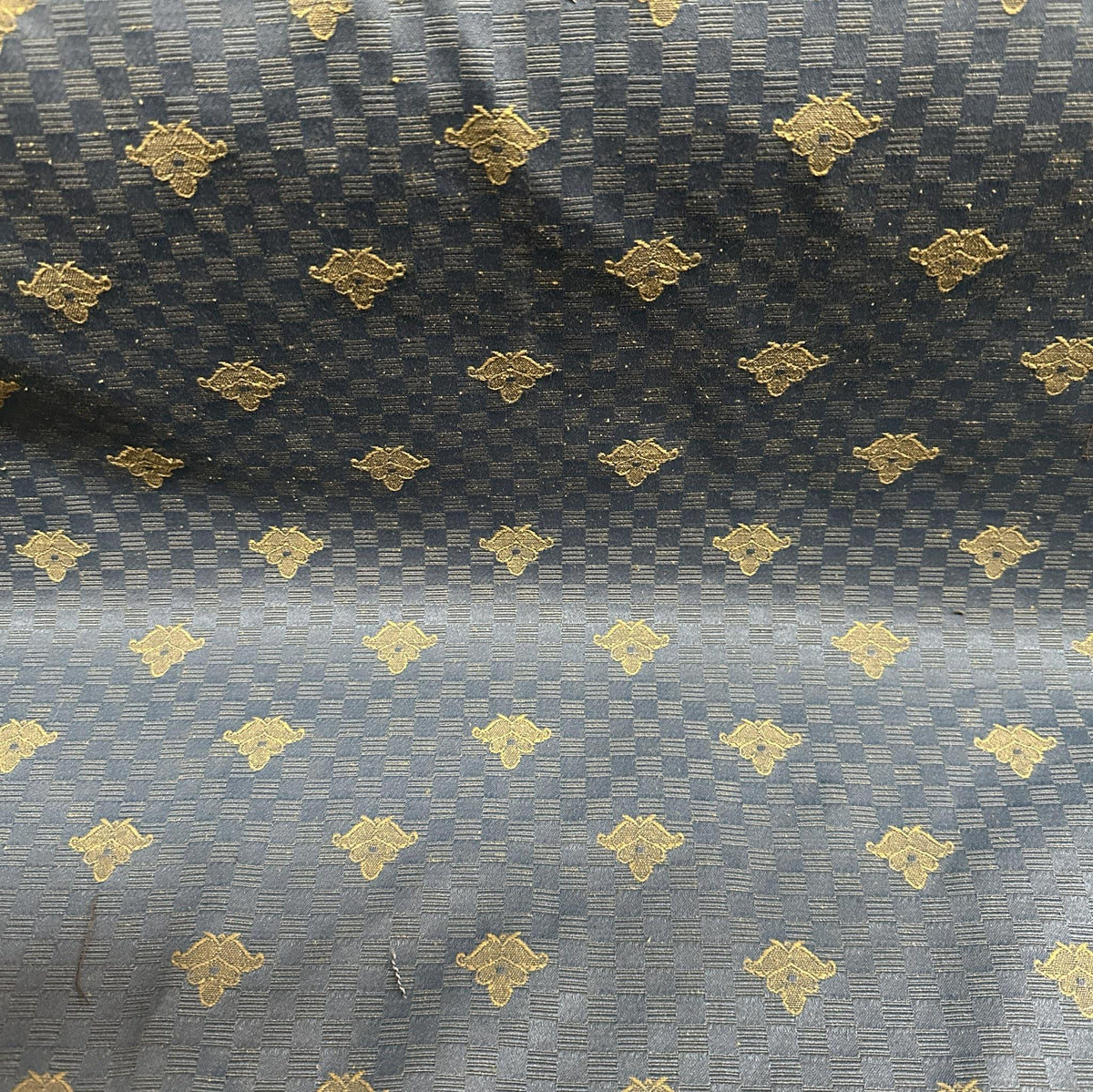 Black and gold upholstery fabric with a decorative butterfly pattern