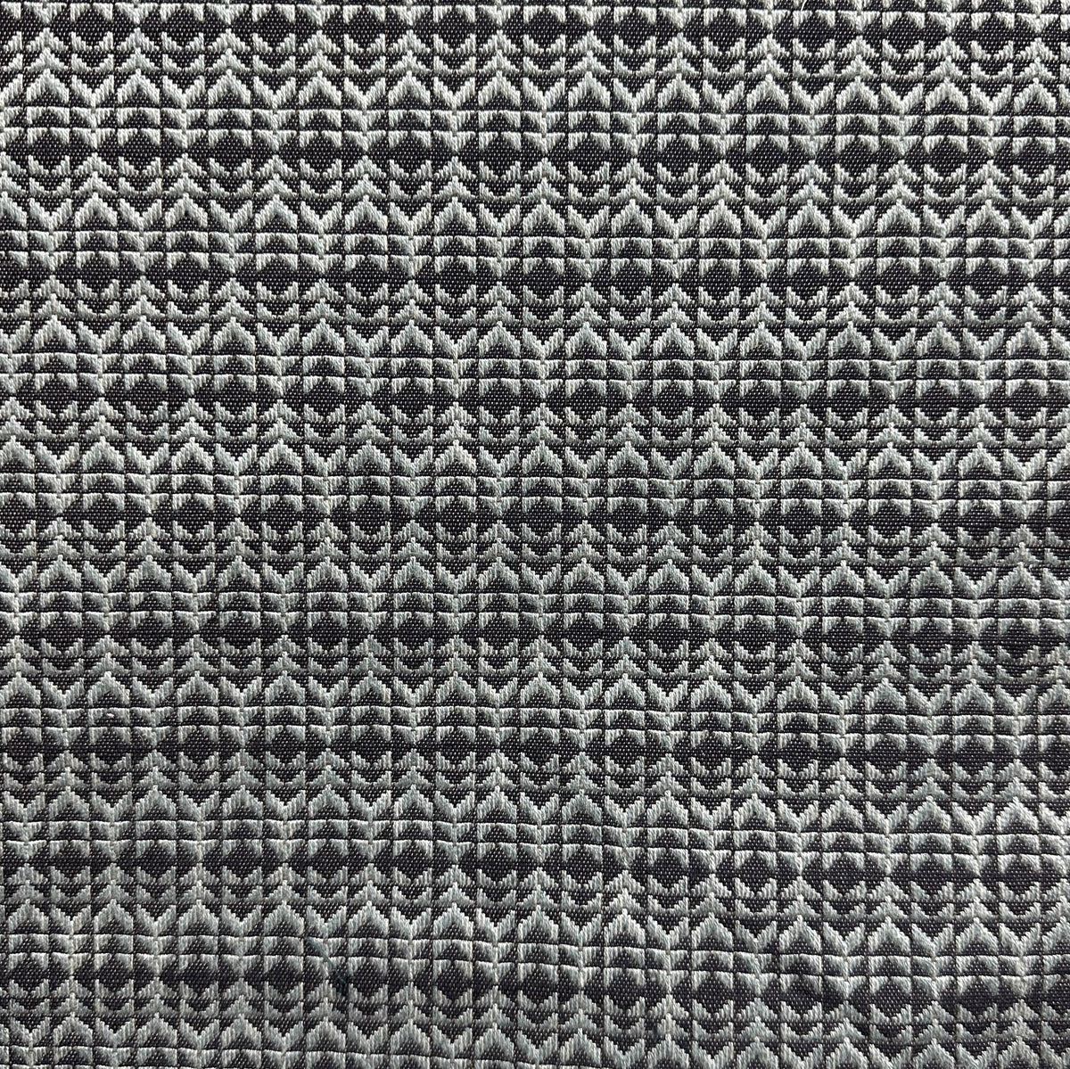 Blue upholstery fabric with a repeating arrow and chevron geometric pattern
