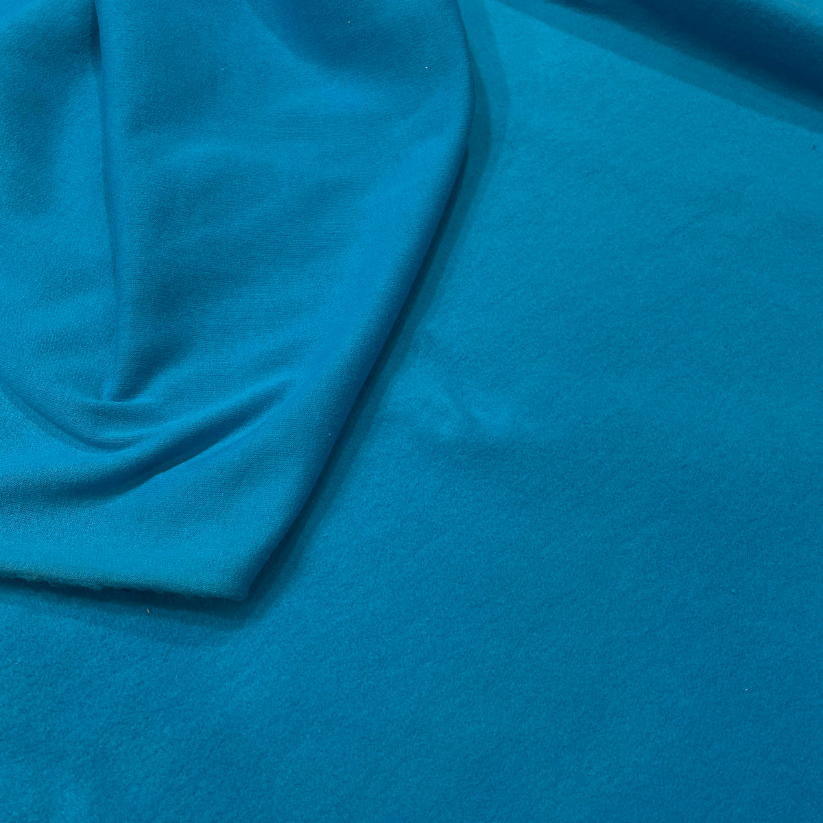 Solid turquoise stretch cotton hoodie fabric with a lightweight apparel-friendly appearance