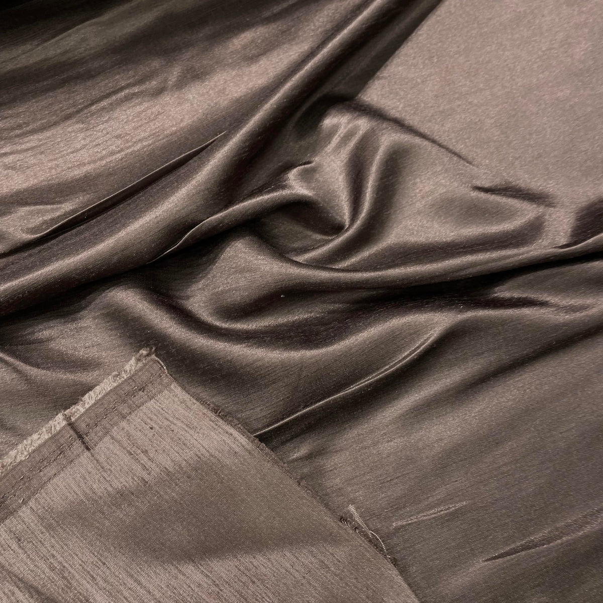 Tussar poly silk fabric in brown with textured surface for apparel and home décor