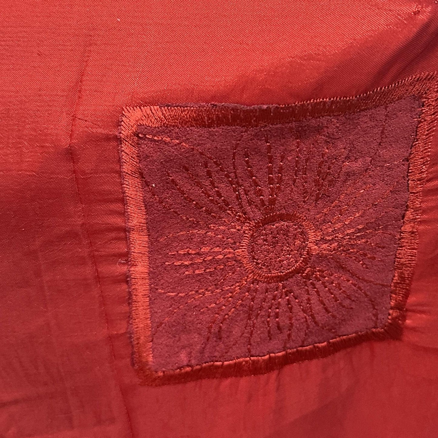 Red embroidered drapery fabric with a textured decorative surface