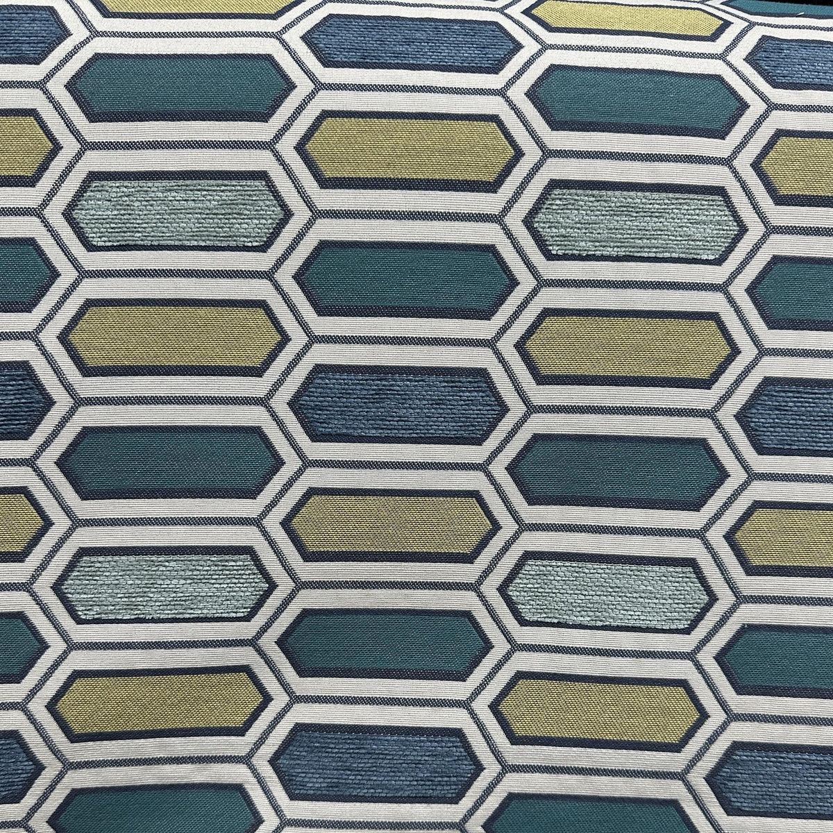 Blue, green and grey upholstery fabric with a repeating elongated hexagon geometric pattern