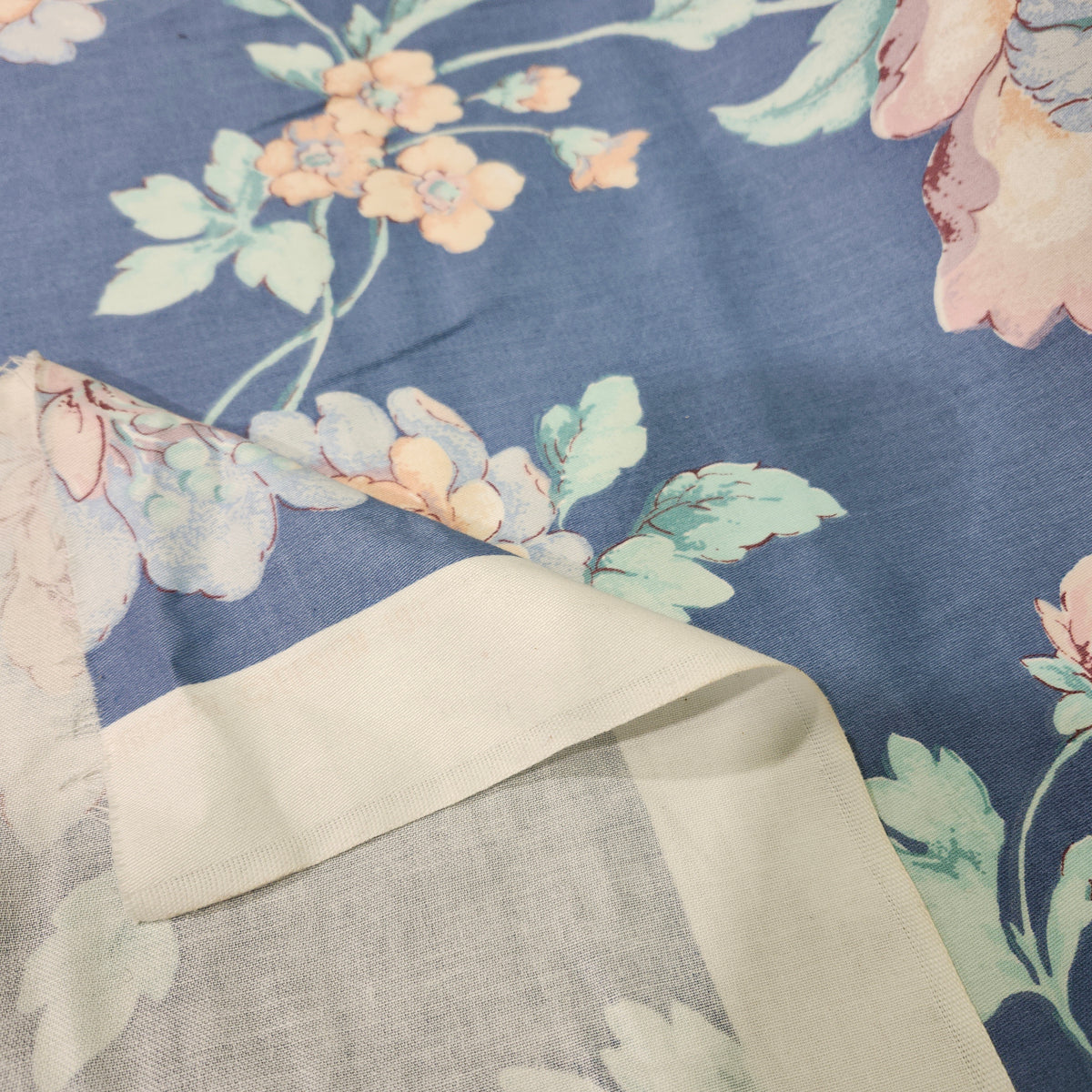 Beige floral 100% cotton fabric with a printed flower pattern and smooth woven texture