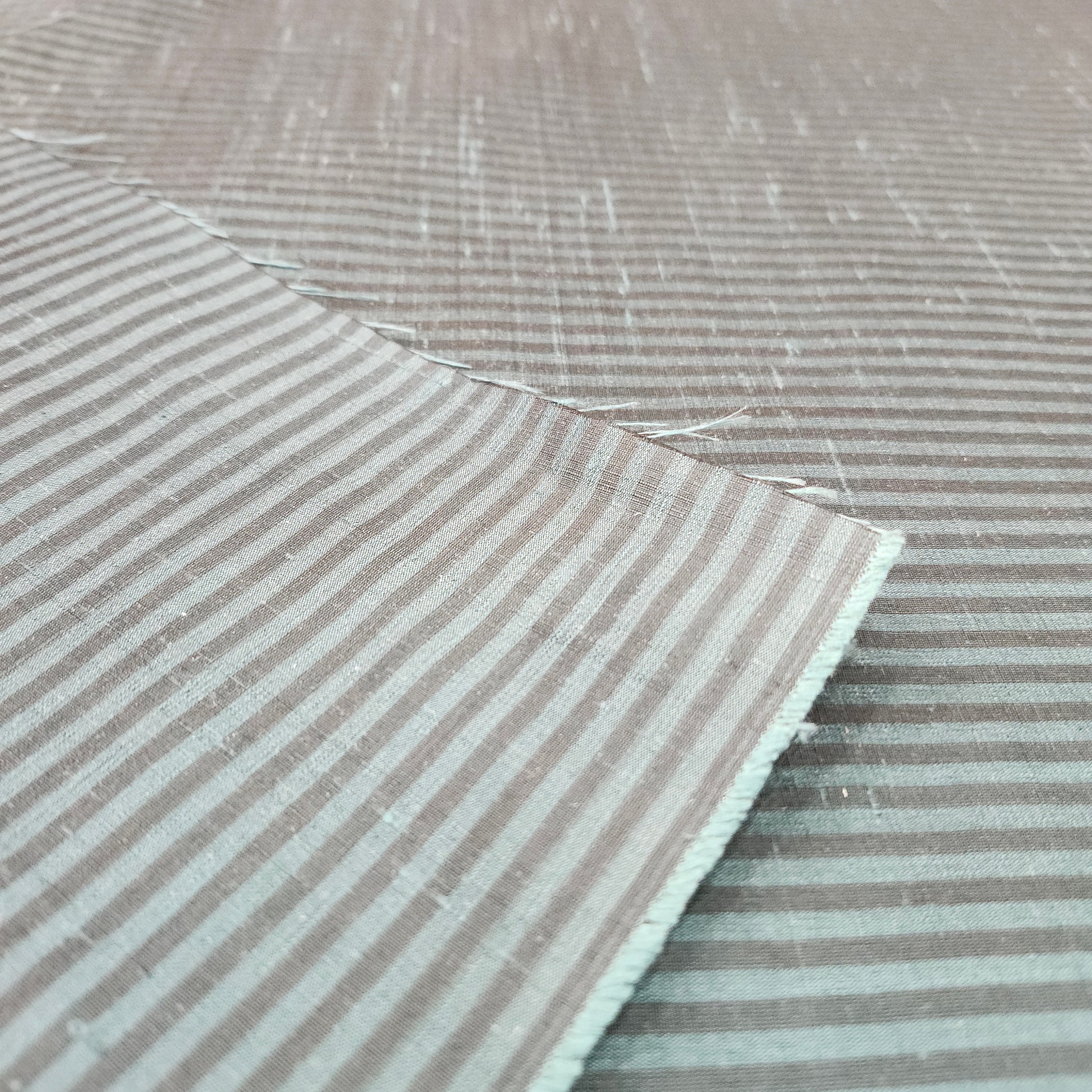 Green and black striped silk fabric with a smooth finish and elegant woven texture